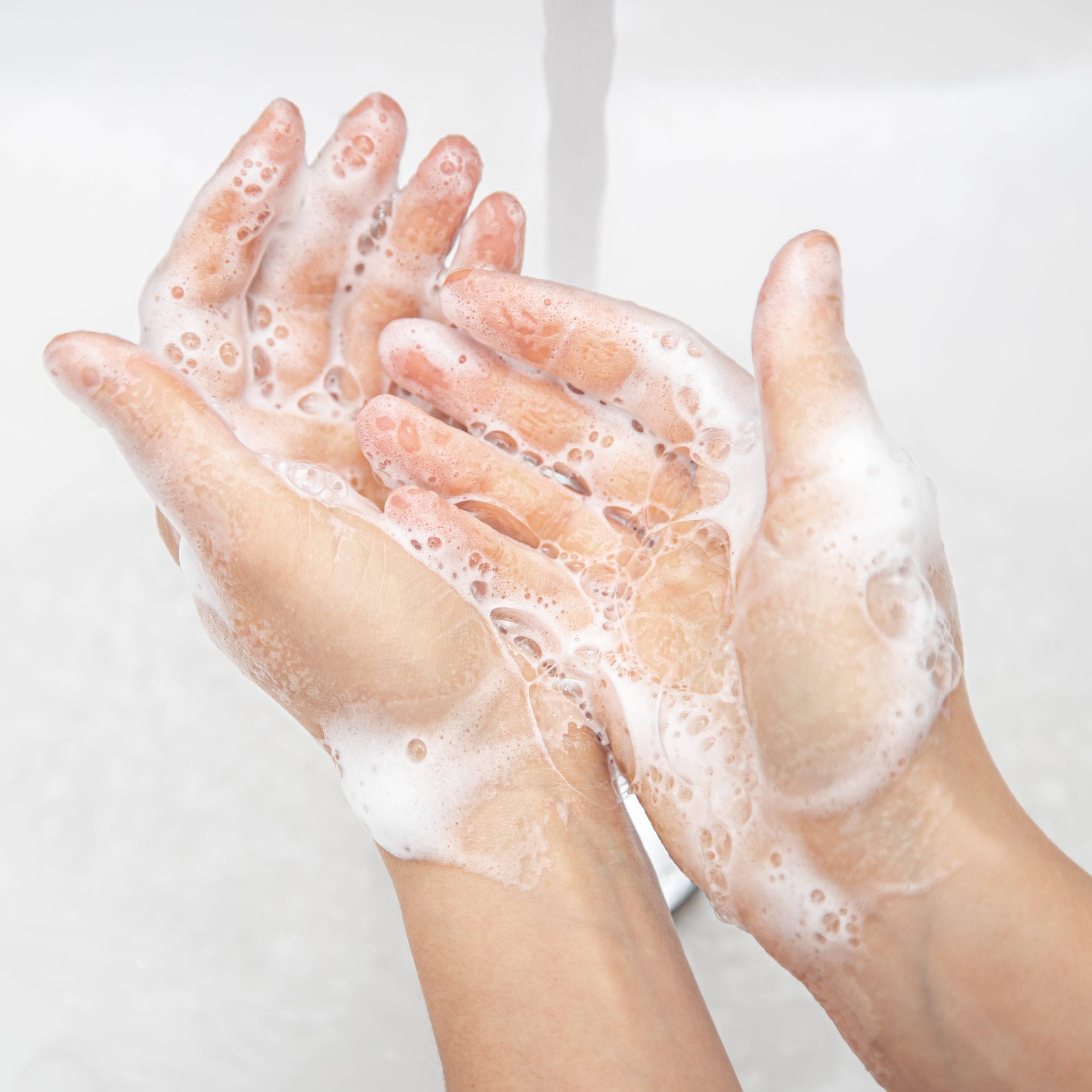 Women's hands in soapy foam. Hand hygiene and health concept.