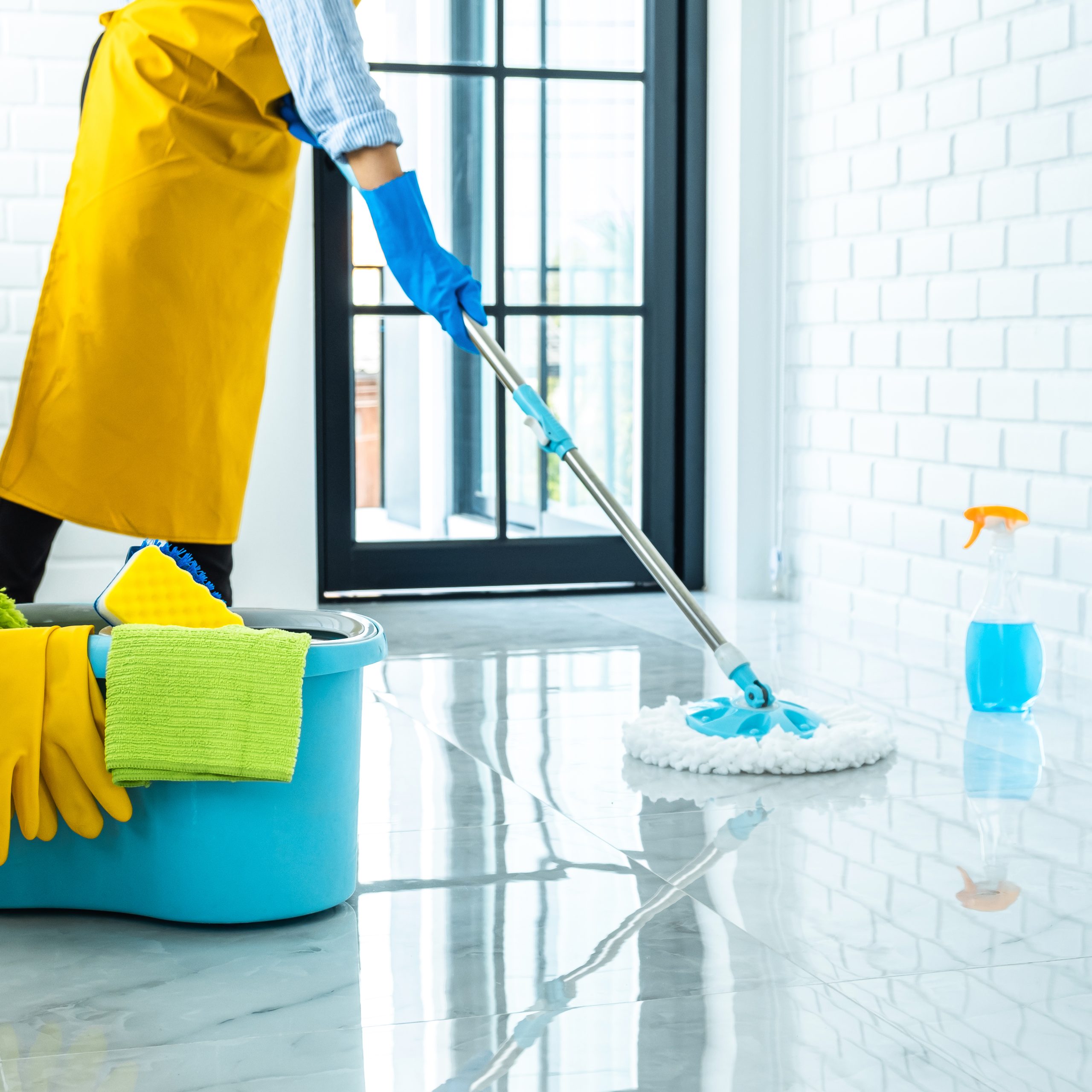 Wife housekeeping and cleaning concept, Happy young woman in blue rubber gloves wiping dust using mop while cleaning on floor at home.