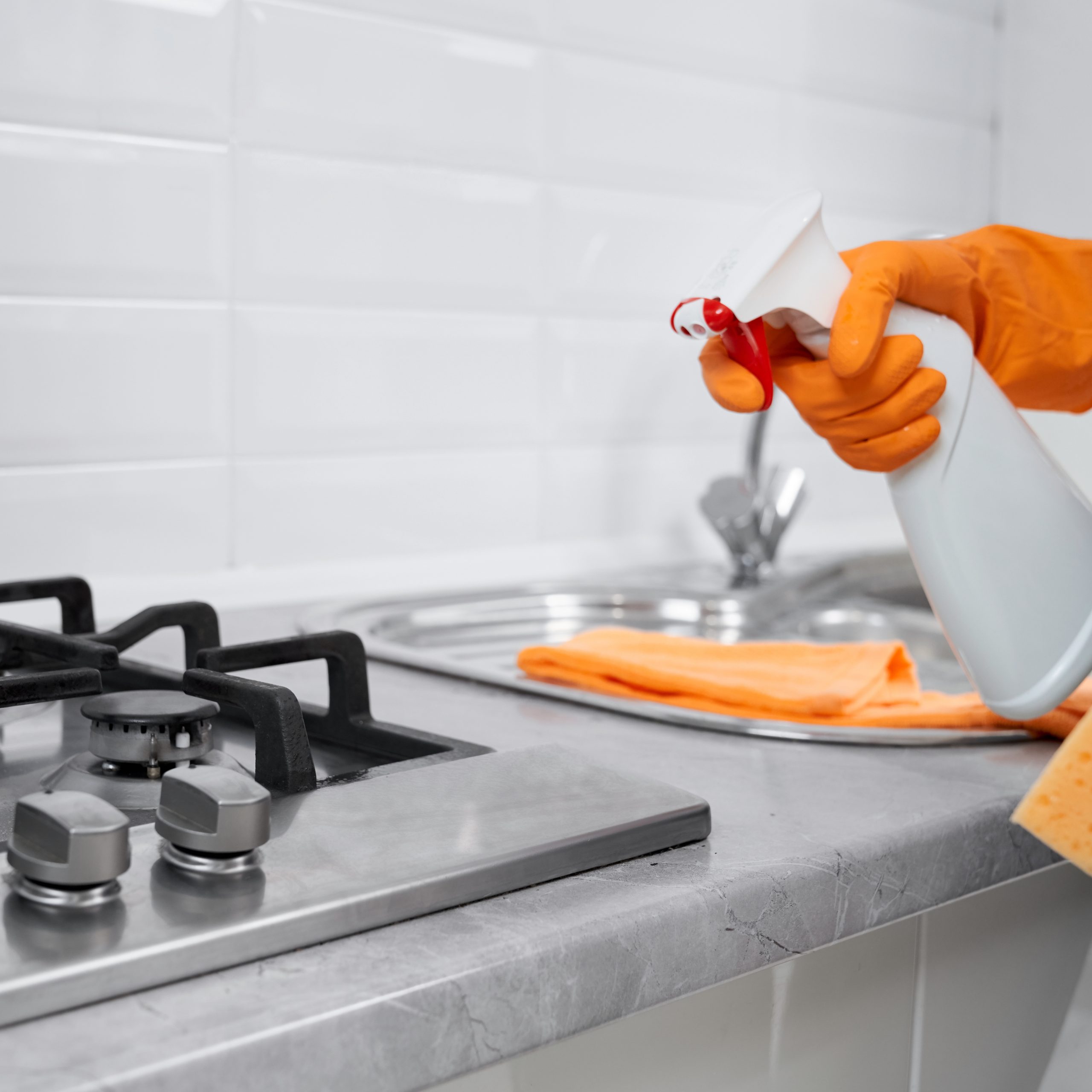 Close up of woman holding rag and detergent for cleaning cooker. Concept of cleaning at home.